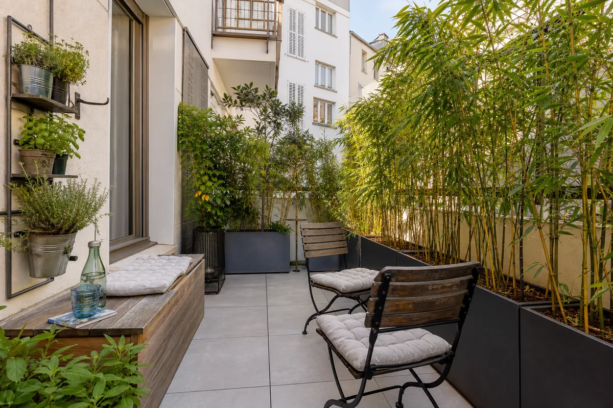 Coin détente sur petite terrasse avec bacs plantés et mobilier compact