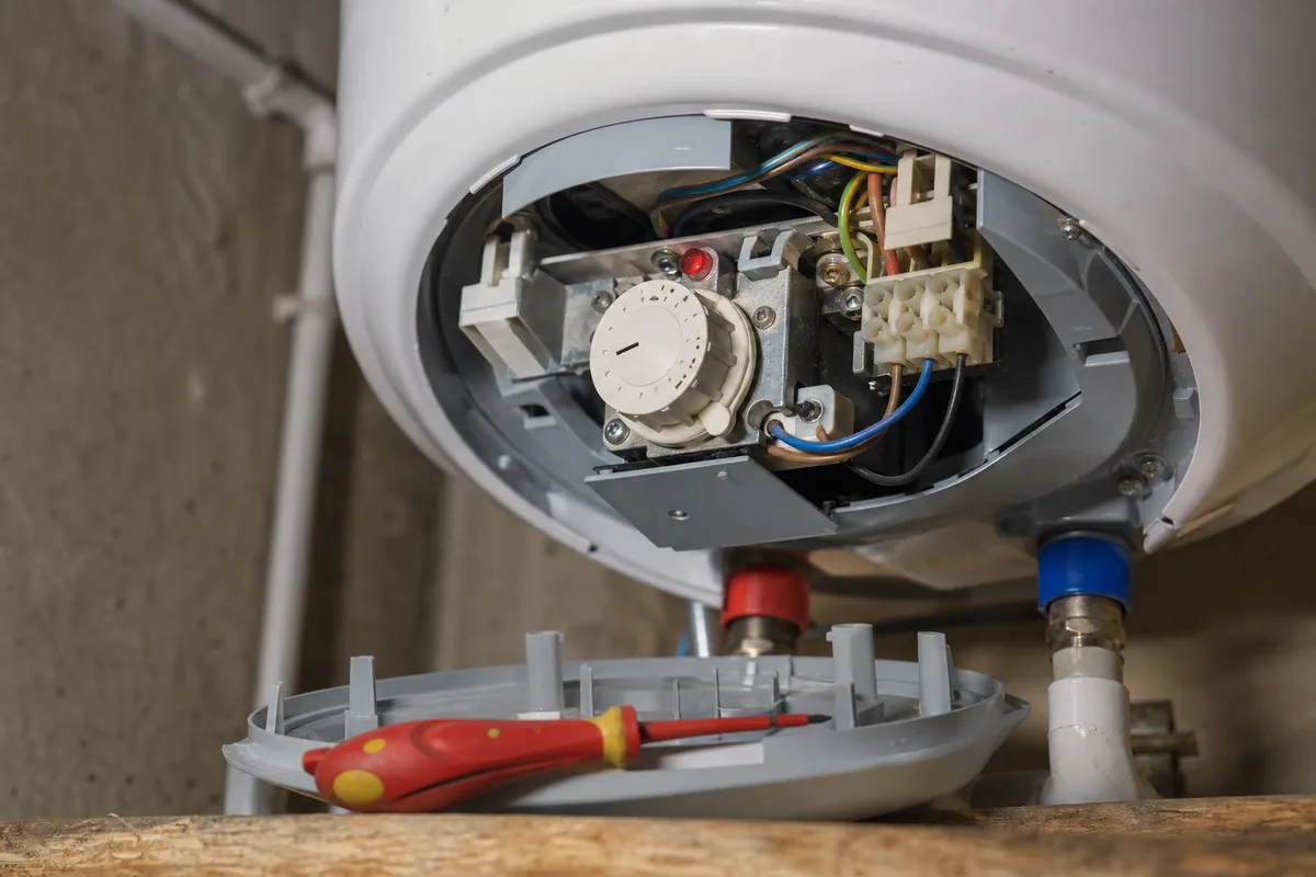 Thermostat d&rsquo;un chauffe-eau électrique accessible sous le capot, réglage à la main