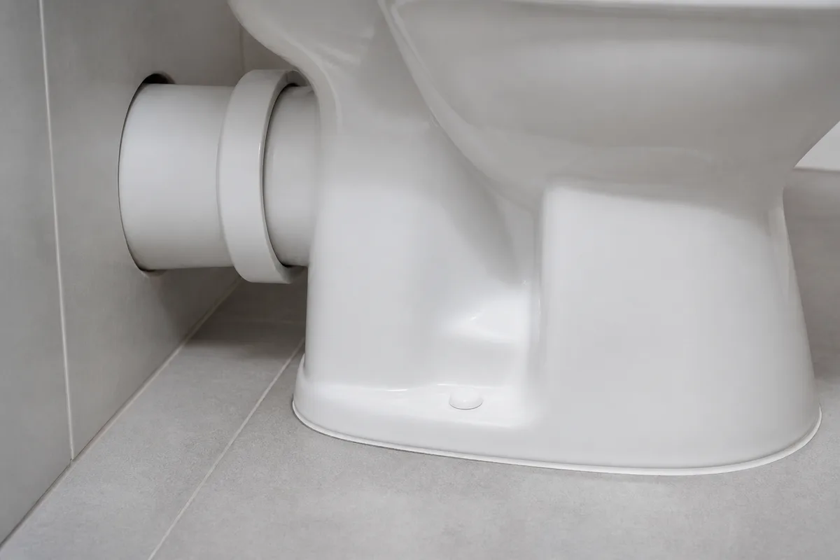 Cuvette de WC blanche et réservoir dans une salle de bains claire